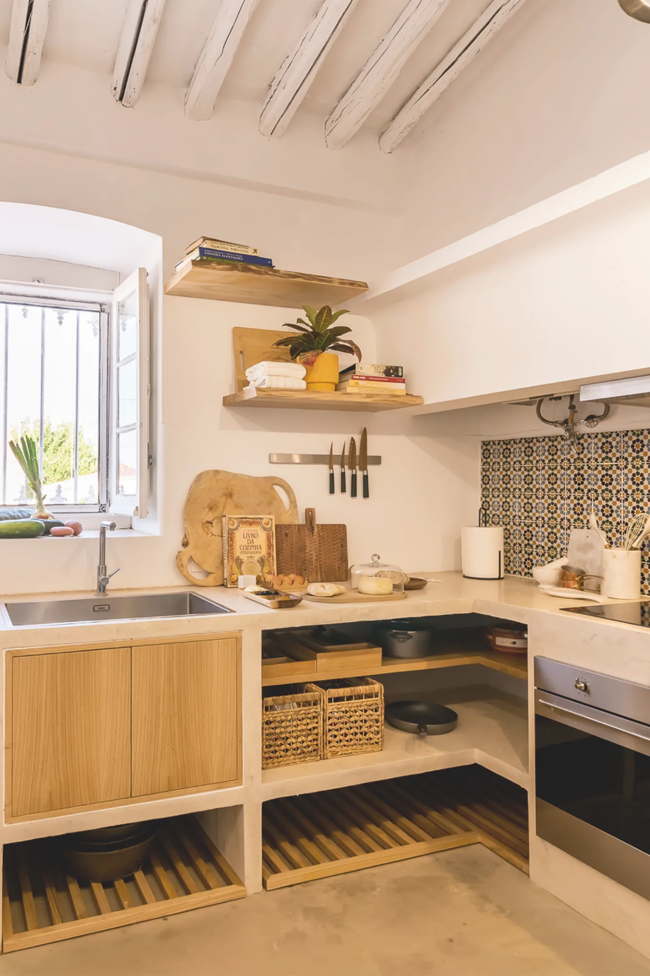 Cozinha com bancada em madeira, azulejo padronizado e prateleiras abertas.
