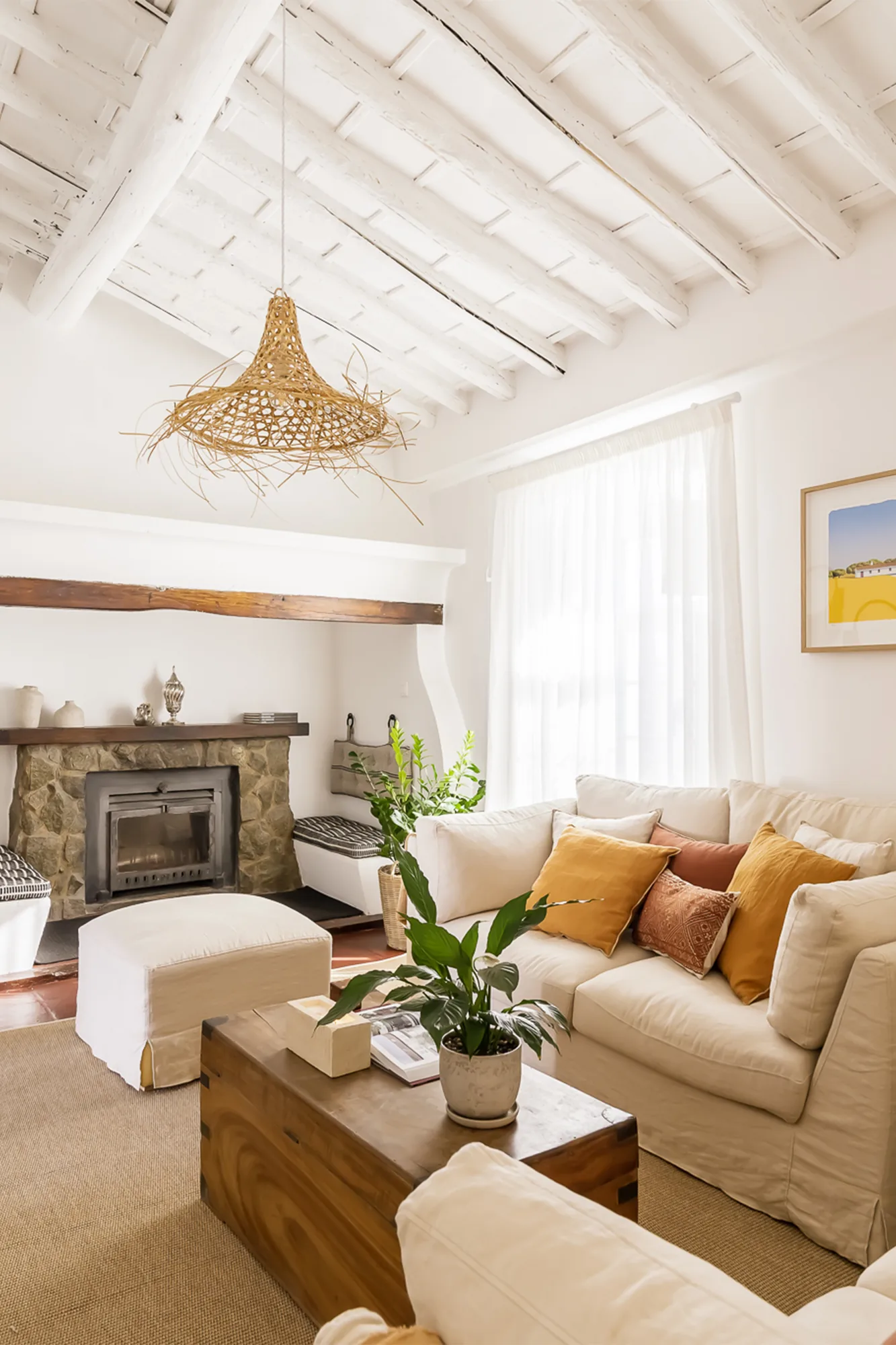 Sala de estar com lareira, sofá claro e mesa de centro em madeira.